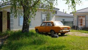 Orange vintage car parked in front of a house